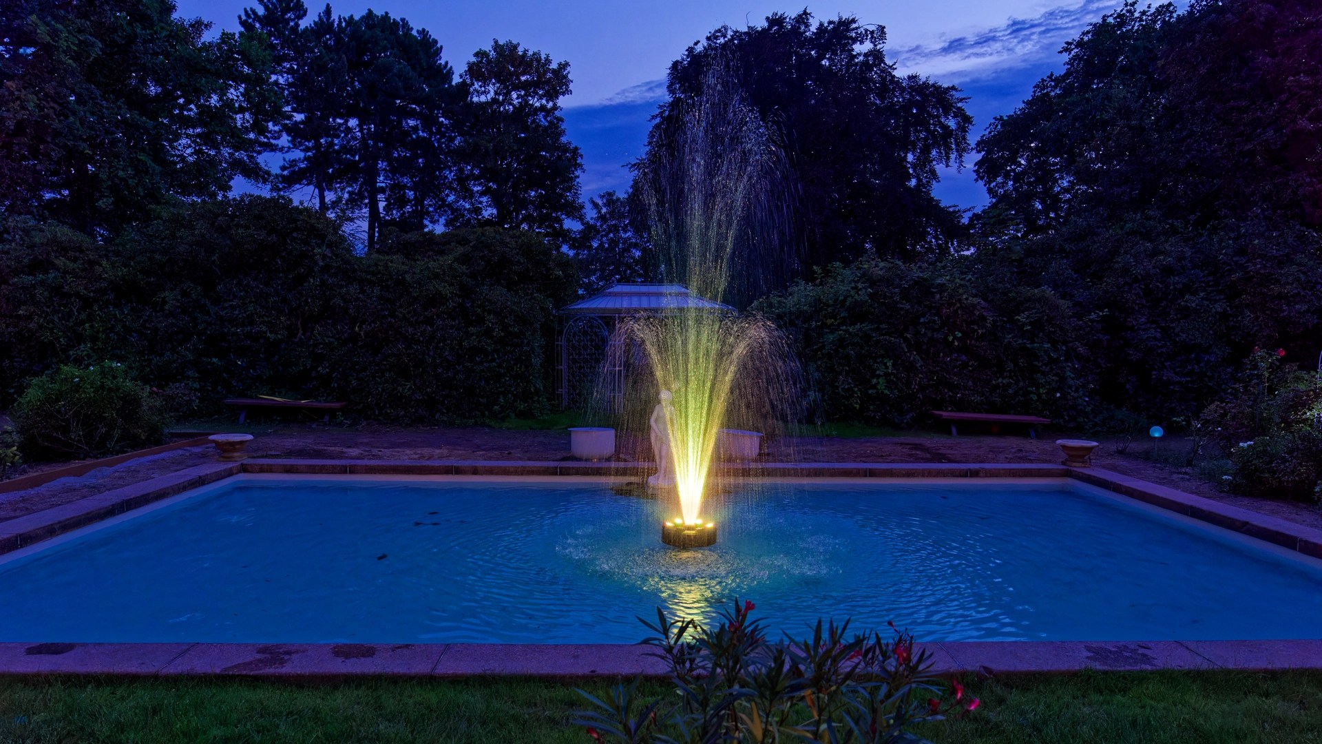 Beleuchteter Brunnen im Park der Villa Bleichert am Abend – entspannte Ferienatmosphäre und stimmungsvolle Abende nahe Leipzig